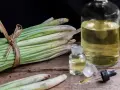 Huiles essentielles de citronnelle anti moustique, avec des tiges fraîches et des petites fioles sur fond sombre.