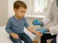 Un enfant subit un test cutané pour diagnostiquer une allergie au maïs. Le médecin, ganté, utilise un instrument pour introduire des allergènes sur son bras.