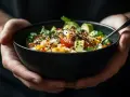 Un bol de riz coloré garni d'avocat, de tomates et de graines de sésame, prêt à être dégusté.
