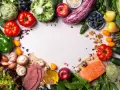 Un assortiment coloré de fruits et légumes frais, de poisson et de quelques tranches de viande, suggérant des alternatives pour remplacer la viande.