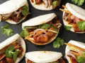 Bao nourriture : petits pains moelleux garnis de porc braisé, de concombre, de carottes et de coriandre fraîche.