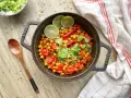 Un délicieux curry thaï végétarien aux pois chiches, tomates et coriandre, garni de quartiers de citron vert.