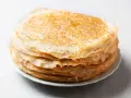 Pile de crêpes dorées, parfaites pour remplacer la farine de blé par de la farine de riz pour une texture légère.