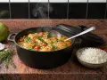 Un plat fumant de poulet au riz et lait de coco, garni de tomates cerises et de poivrons. Une invitation à découvrir cette recette savoureuse.