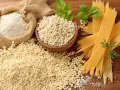 Farine de blé dur dans un sac en toile, à côté de petites pâtes rondes et de pâtes plates striées.