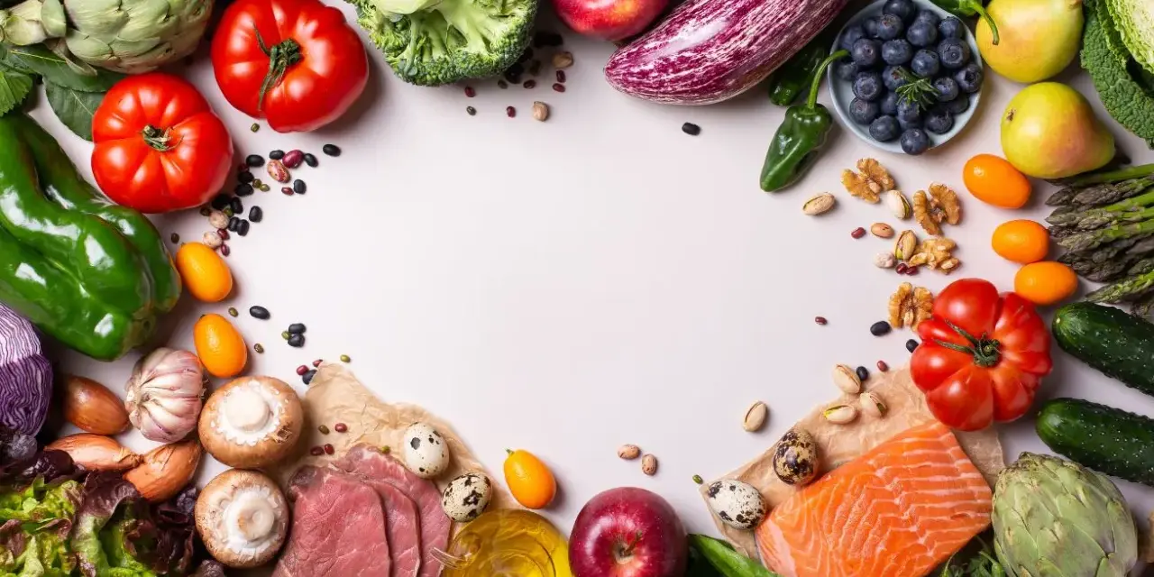 Un assortiment coloré de fruits et légumes frais, de poisson et de quelques tranches de viande, suggérant des alternatives pour remplacer la viande.