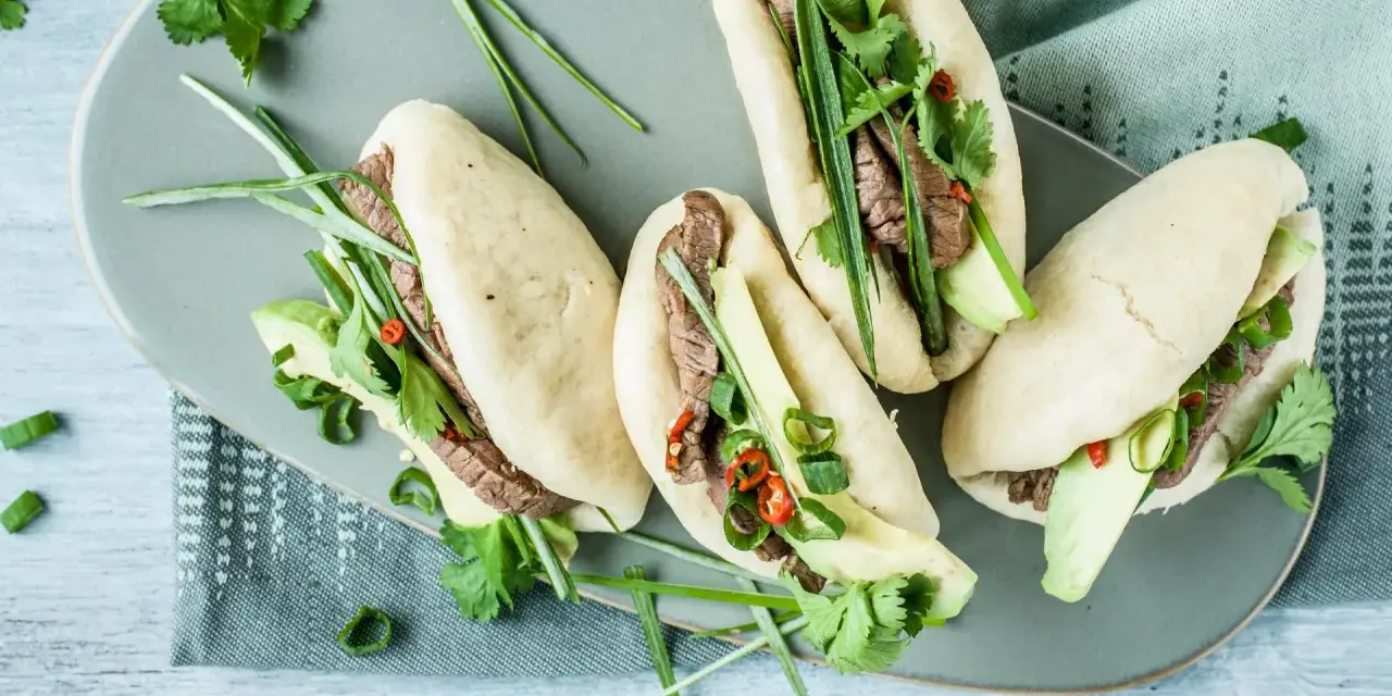 Délicieux bao buns garnis de bœuf, avocat, coriandre et oignons verts. Une recette facile pour un repas savoureux.