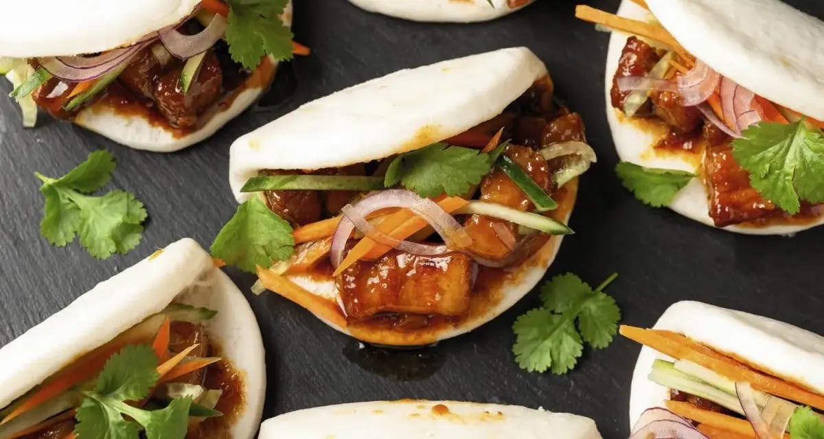 Bao nourriture : petits pains moelleux garnis de porc braisé, de concombre, de carottes et de coriandre fraîche.