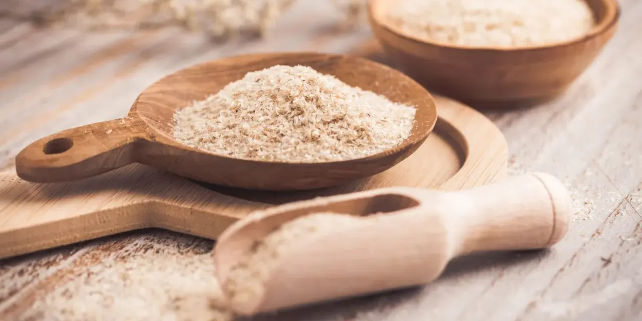 Cuillères en bois remplies de psyllium, une aide naturelle pour le transit.