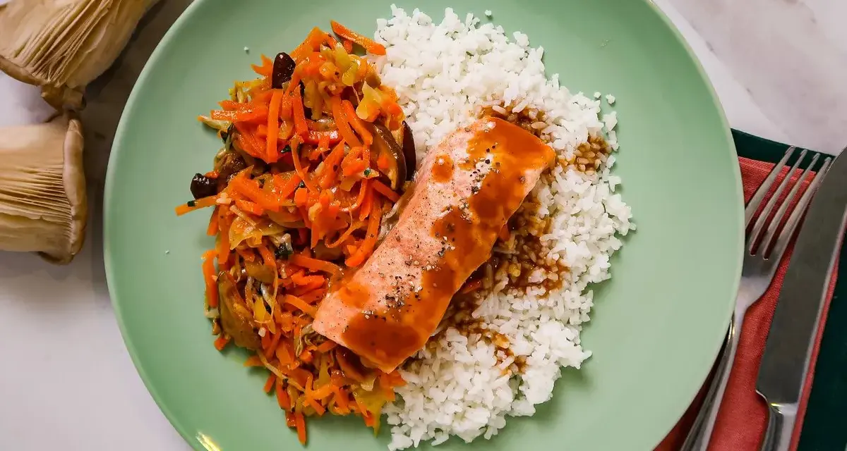 Filet de saumon nappé de sauce teriyaki, servi avec du riz blanc et une julienne de légumes croquants.