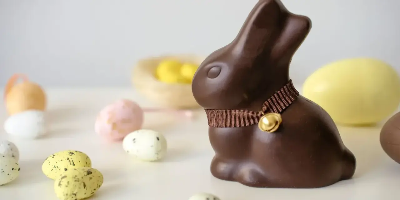 Un lapin en chocolat, entouré d'œufs de Pâques. Attention, le chocolat constipe !