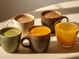 Quatre tasses de boissons colorées : matcha, curcuma, chocolat chaud et boisson dorée. Une belle alternative au café pour commencer la journée.