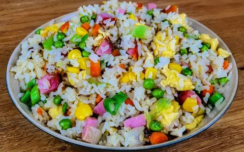 Riz cantonais coloré avec petits pois, maïs, carottes, œuf et jambon. Quelle sauce soja pour riz cantonais ? Une touche de sauce soja rehausse ce plat.