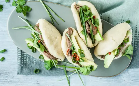 Délicieux bao buns garnis de bœuf, avocat, coriandre et oignons verts. Une recette facile pour un repas savoureux.