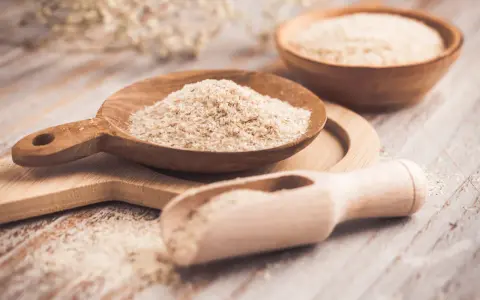 Cuillères en bois remplies de psyllium, une aide naturelle pour le transit.