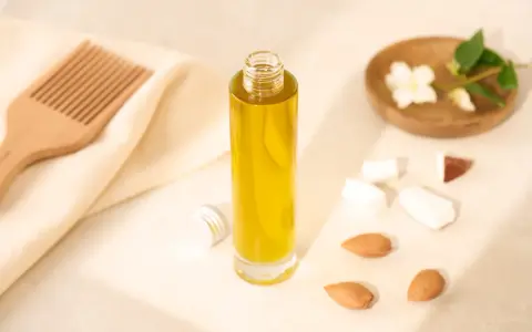 Bouteille d'huile d'amande douce pour les cheveux, avec un peigne en bois, des amandes et des fleurs de jasmin.