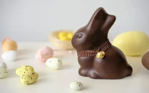 Un lapin en chocolat, entouré d'œufs de Pâques. Attention, le chocolat constipe !