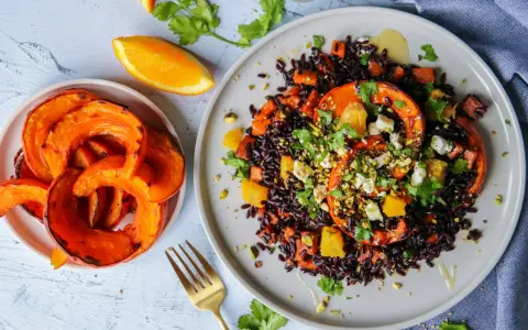 Assiette de riz vénéré aux courges rôties, oranges et feta, garnie de pistaches et coriandre. Un délice visuel et gustatif.