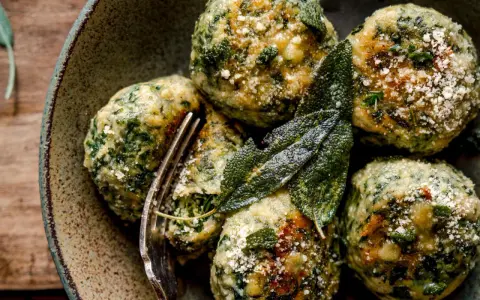 Boules de pain et d'épinards, parsemées de parmesan et garnies de feuilles de sauge. Une délicieuse recette d'épinard à essayer.