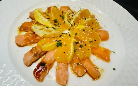 Délicieuse recette saumon cru japonaise : fines tranches de saumon cru, quartiers d'orange, sauce soja, sésame et ciboule.