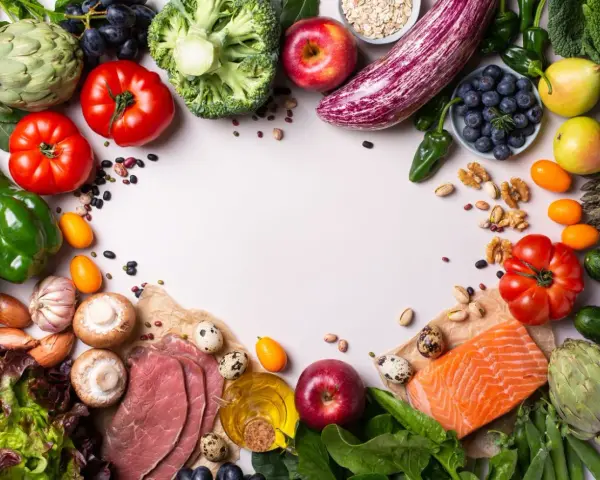 Un assortiment coloré de fruits et légumes frais, de poisson et de quelques tranches de viande, suggérant des alternatives pour remplacer la viande.