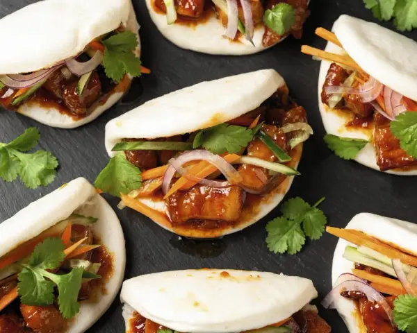 Bao nourriture : petits pains moelleux garnis de porc braisé, de concombre, de carottes et de coriandre fraîche.