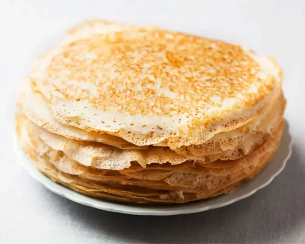 Pile de crêpes dorées, parfaites pour remplacer la farine de blé par de la farine de riz pour une texture légère.