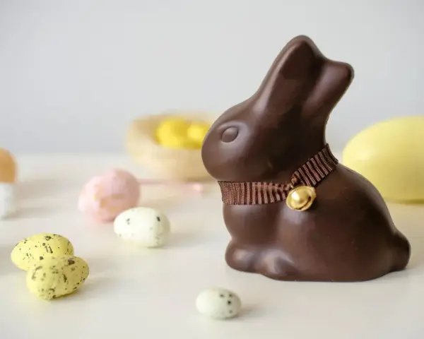 Un lapin en chocolat, entouré d'œufs de Pâques. Attention, le chocolat constipe !