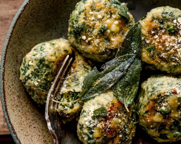 Boules de pain et d'épinards, parsemées de parmesan et garnies de feuilles de sauge. Une délicieuse recette d'épinard à essayer.
