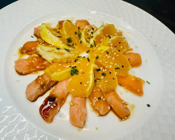Délicieuse recette saumon cru japonaise : fines tranches de saumon cru, quartiers d'orange, sauce soja, sésame et ciboule.