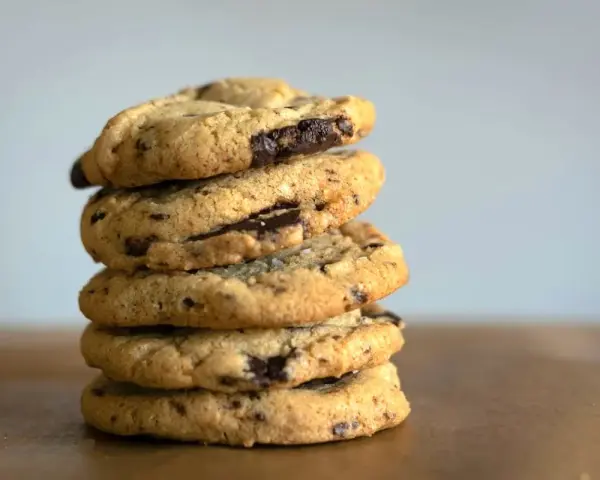 Pile de délicieux cookies aux pépites de chocolat, faits avec de l'huile de coco pour une texture parfaite.