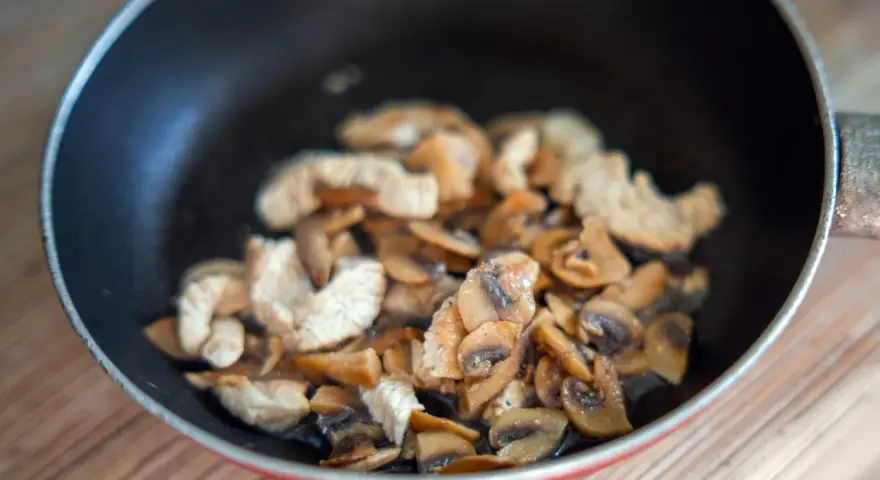 Champignons et poulet sautés dans une poêle. Une recette à éviter si vous avez une allergie champignon.