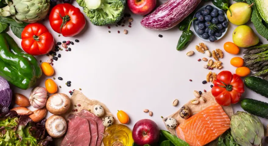 Un assortiment coloré de fruits et légumes frais, de poisson et de quelques tranches de viande, suggérant des alternatives pour remplacer la viande.