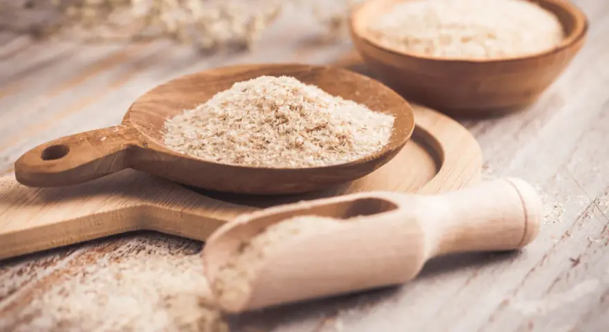 Cuillères en bois remplies de psyllium, une aide naturelle pour le transit.