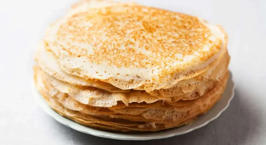Pile de crêpes dorées, parfaites pour remplacer la farine de blé par de la farine de riz pour une texture légère.