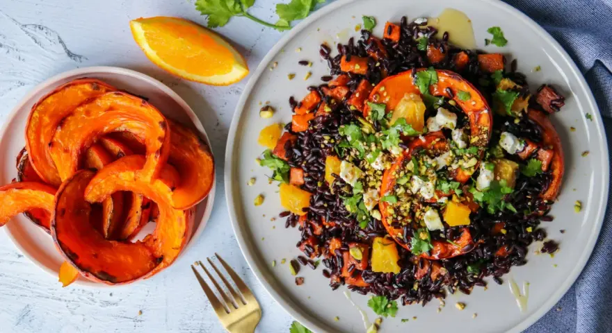 Assiette de riz vénéré aux courges rôties, oranges et feta, garnie de pistaches et coriandre. Un délice visuel et gustatif.