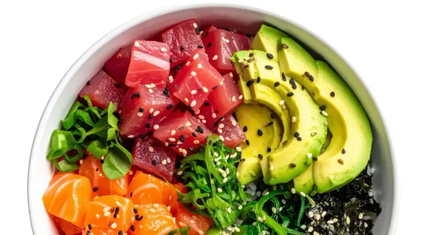 Un délicieux poke bowl avec thon, saumon, avocat, algues et sauce, garni de graines de sésame.