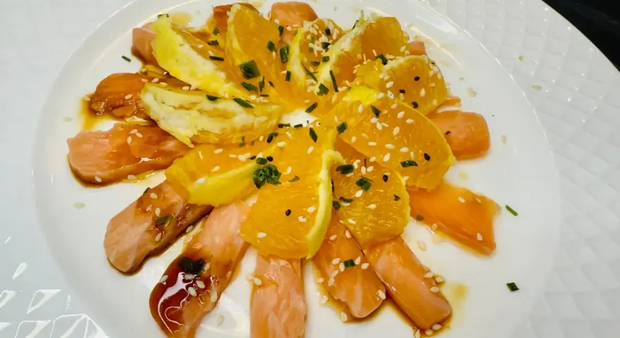 Délicieuse recette saumon cru japonaise : fines tranches de saumon cru, quartiers d'orange, sauce soja, sésame et ciboule.