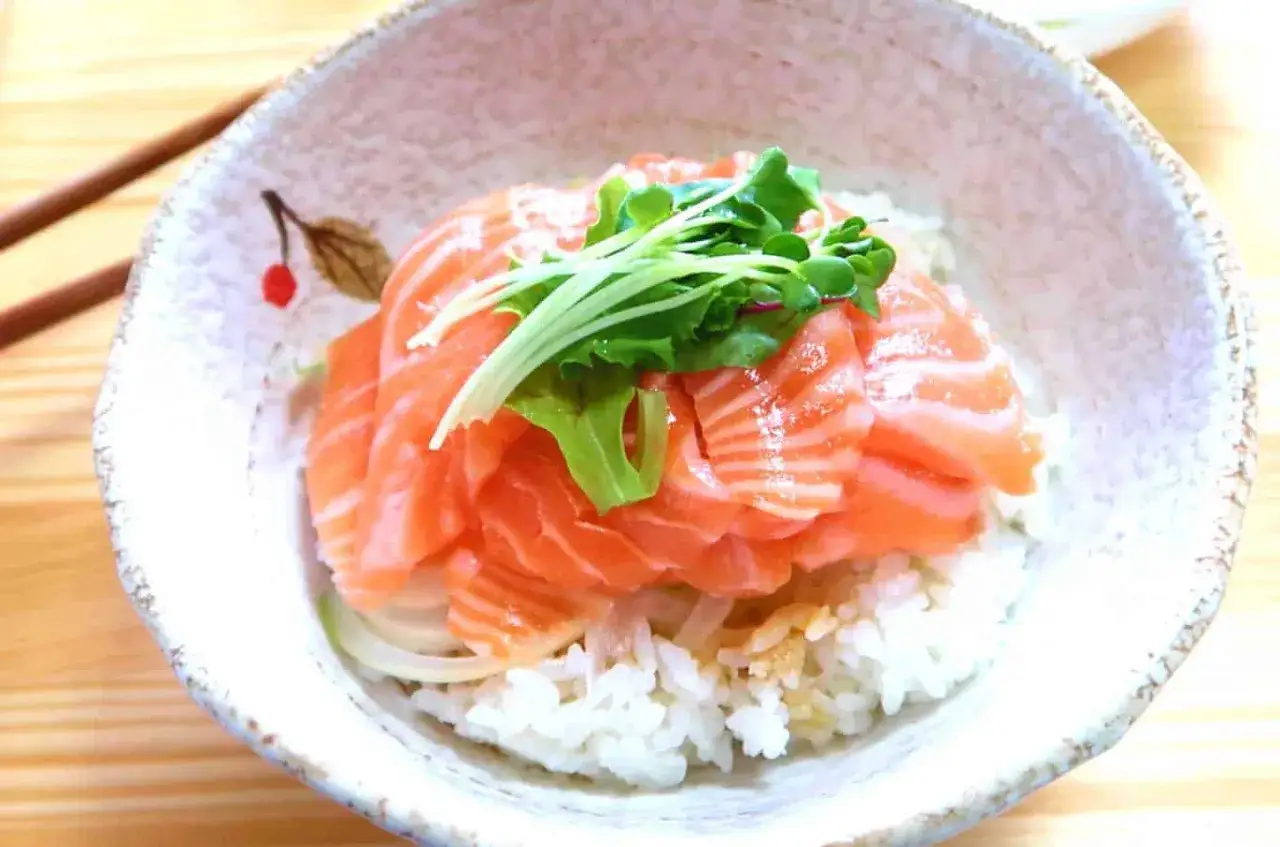 Un bol de riz garni de fines tranches de saumon cru, de fines herbes et d'oignon. Une d&eacute;licieuse recette saumon cru japonaise.
