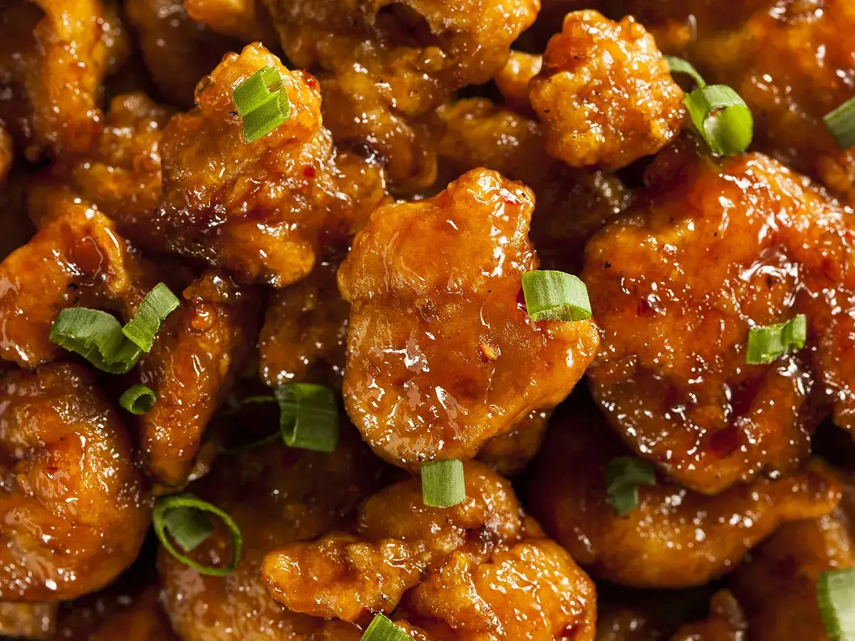 Morceaux de poulet asiatique croustillants, enrob&eacute;s d'une sauce sucr&eacute;e et &eacute;pic&eacute;e, parsem&eacute;s de ciboule fra&icirc;che. Un d&eacute;lice de poulet asiatique marinade.