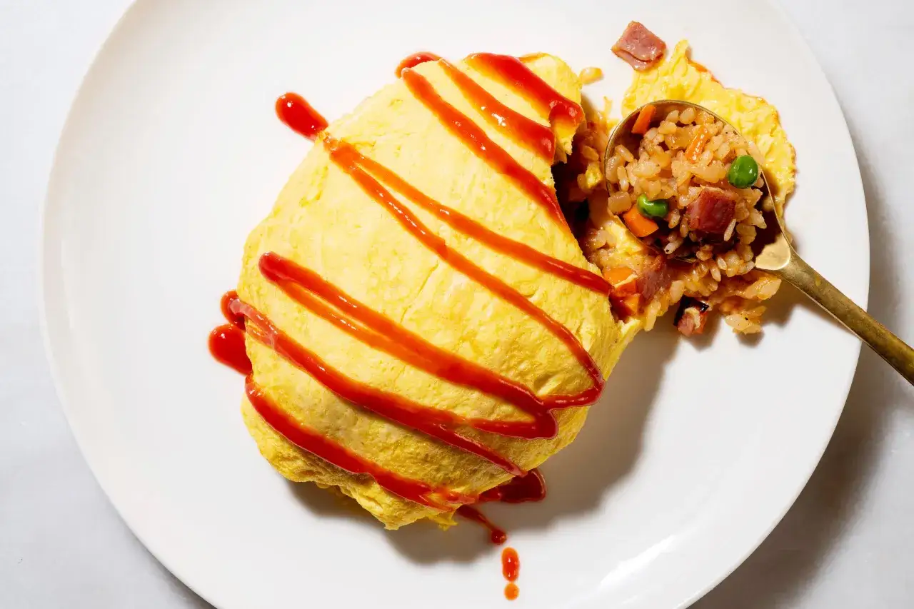 Omelette japonaise riz, un plat r&eacute;confortant avec une omelette moelleuse garnie de sauce tomate, servie avec du riz frit aux l&eacute;gumes et au jambon.