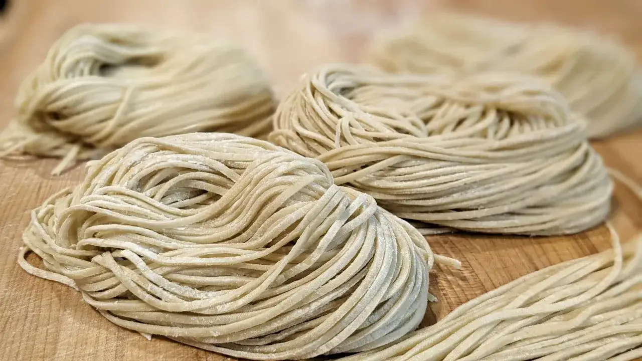 Des tas de nouilles fra&icirc;ches, pr&ecirc;tes &agrave; &ecirc;tre cuisin&eacute;es. Un aper&ccedil;u de comment faire des nouilles maison pour un repas d&eacute;licieux.