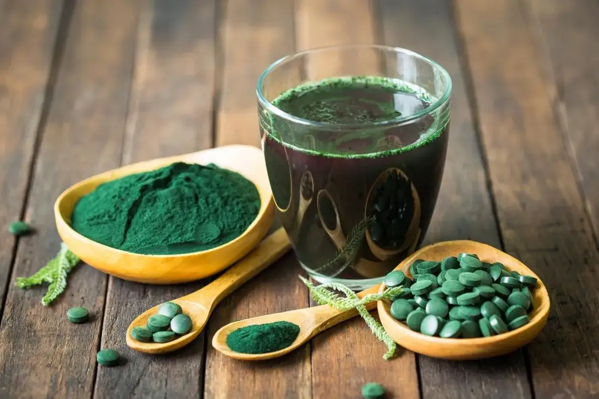 Verre de boisson verte, poudre et comprim&eacute;s de spiruline, parfaits pour la sant&eacute; des cheveux.