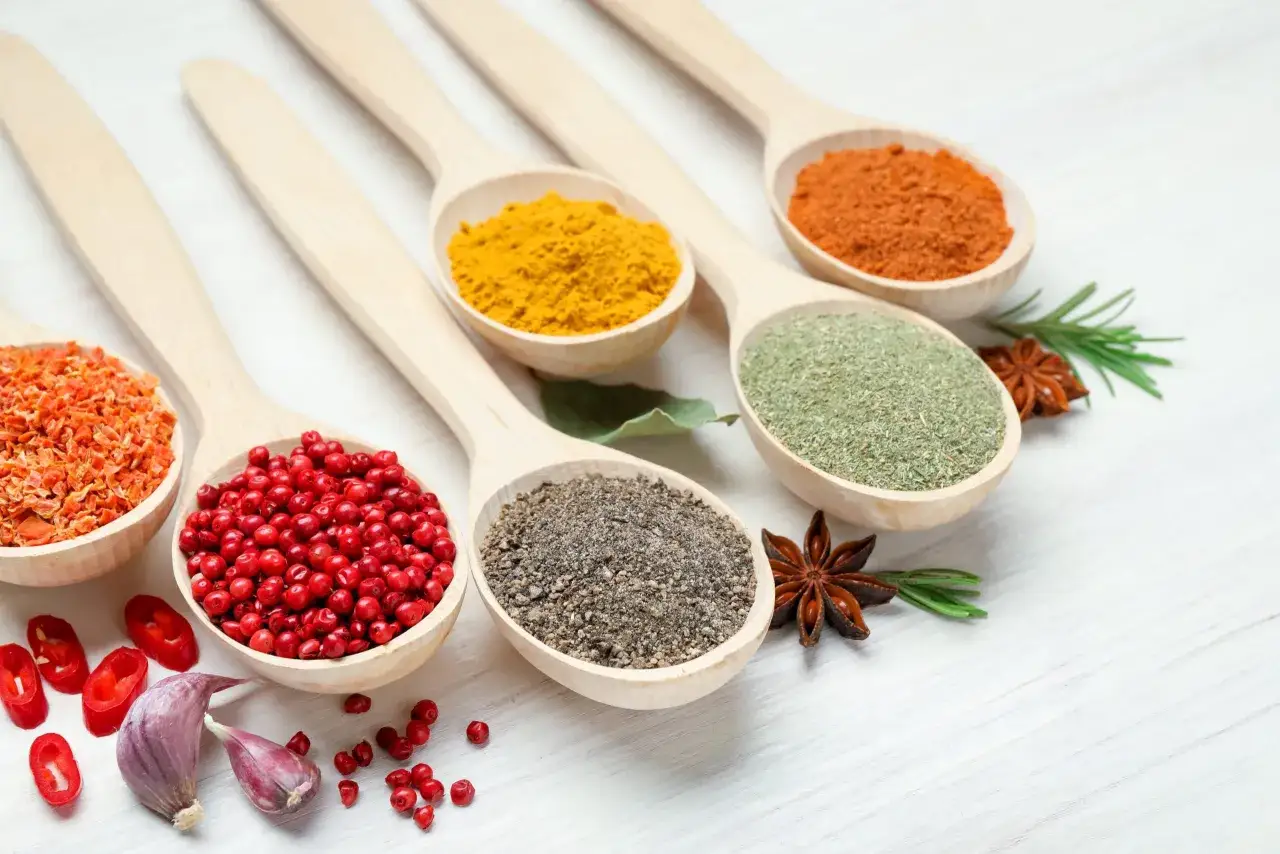 Cuill&egrave;res en bois remplies d'&eacute;pices color&eacute;es : curcuma, poivre, herbes, piment. Laquelle est l'anti-inflammatoire naturel le plus efficace ?