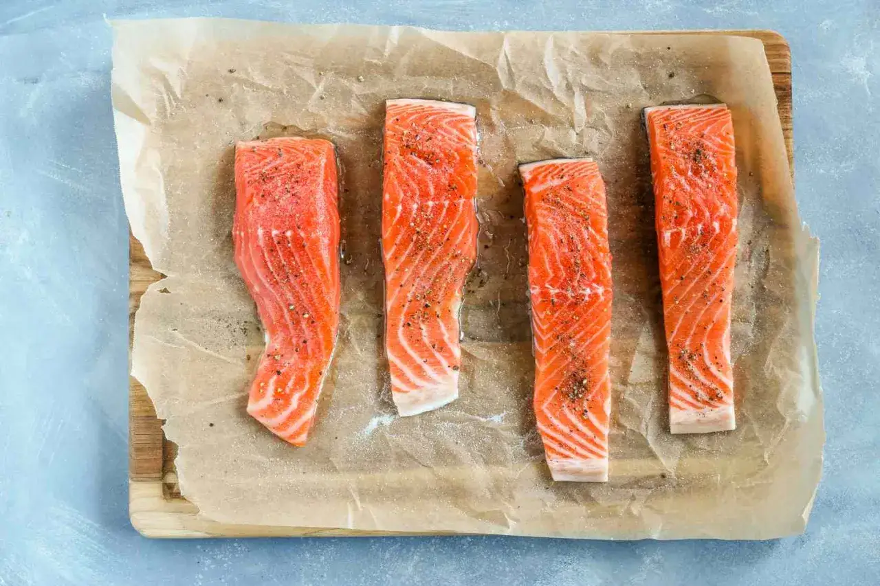 Quatre pav&eacute;s de saumon crus, assaisonn&eacute;s de sel et de poivre, pr&ecirc;ts &agrave; &ecirc;tre cuits. Une pens&eacute;e pour ceux qui ont une allergie au saumon.