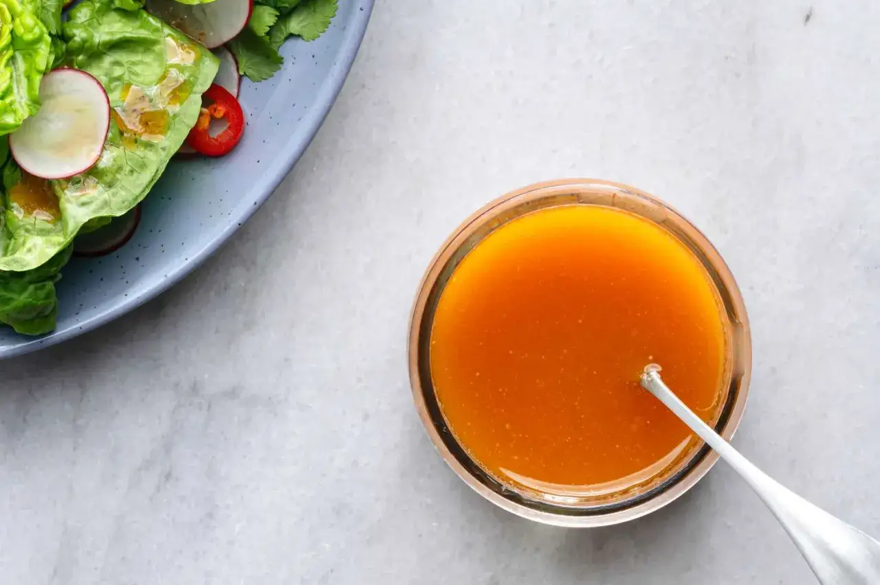 Vinaigrette orange vif, &agrave; base de vinaigre de riz, pr&ecirc;te &agrave; napper une salade fra&icirc;che de laitue et radis.
