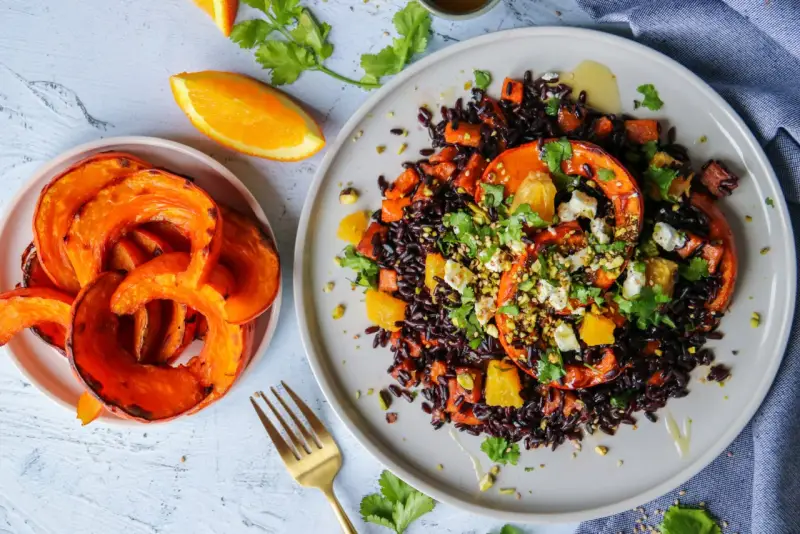 Assiette de riz vénéré aux courges rôties, oranges et feta, garnie de pistaches et coriandre. Un délice visuel et gustatif.